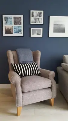 a brown chair with a striped pillow in a living room at Great Northern Road Apartment in Cambridge