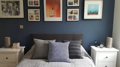 a bedroom with blue walls and a bed with pillows at Great Northern Road Apartment in Cambridge