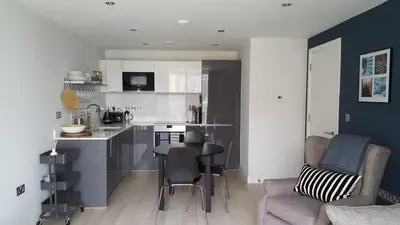 a kitchen and living room with a table and chairs at Great Northern Road Apartment in Cambridge