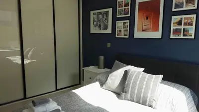 a bedroom with a bed and some pictures on the wall at Great Northern Road Apartment in Cambridge