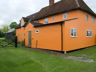 a large orange house with a green yard at Woodview B Colchester in Birch