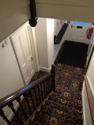 an overhead view of a staircase with a door and a rug at Fairways Guest House in Cambridge