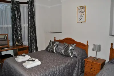 a bedroom with a bed with towels on it at Fairways Guest House in Cambridge