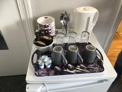 a refrigerator with a tray of utensils and drinks at Fairways Guest House in Cambridge