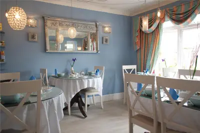 a dining room with a table and chairs and a mirror at The Cambridge Guest House by Tas in Cambridge