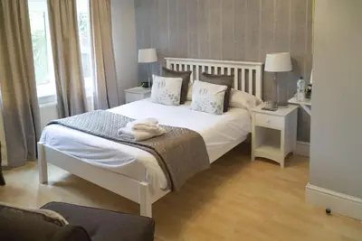 a bedroom with a large white bed with two night stands at The Cambridge Guest House by Tas in Cambridge