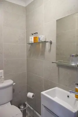 a bathroom with a white toilet and a sink at The Cambridge Guest House by Tas in Cambridge