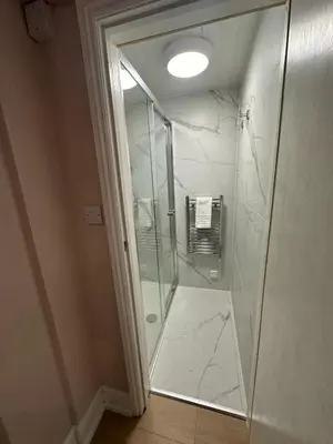 a shower with a glass door in a bathroom at The Cambridge Guest House by Tas in Cambridge