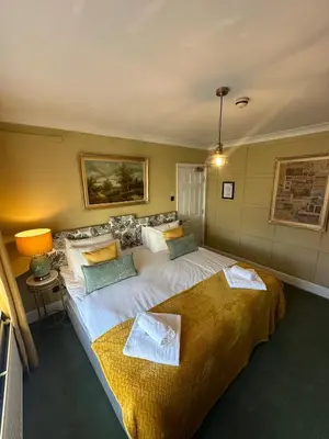 a bedroom with a large bed with two pillows at The Cambridge Guest House by Tas in Cambridge