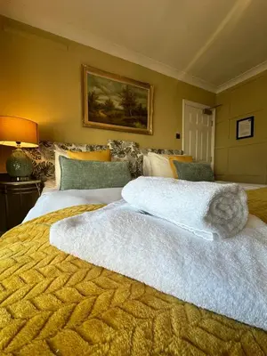 a large bed with two white towels on top of it at The Cambridge Guest House by Tas in Cambridge
