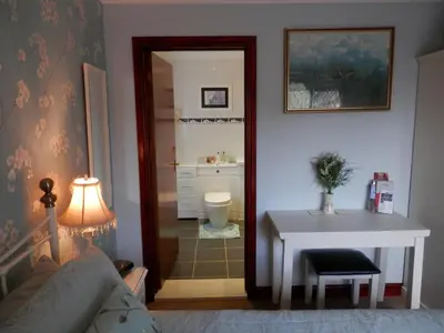 a living room with a table and a bathroom at Finjaro in Sproughton