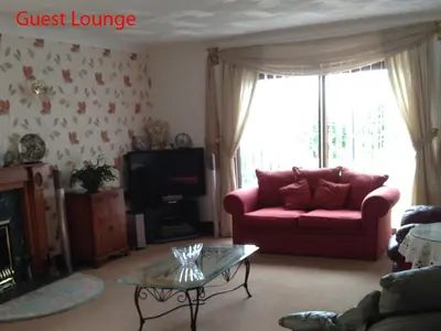 a living room with a red couch and a glass table at Finjaro in Sproughton