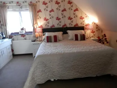 a bedroom with a large bed with a white bedspread at Finjaro in Sproughton