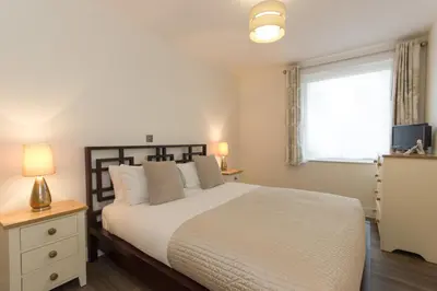 a bedroom with a large bed and a window at Citystay Living - Mill Park Apartments in Cambridge