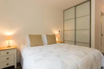 a bedroom with a large white bed with two lamps at Citystay Living - Mill Park Apartments in Cambridge