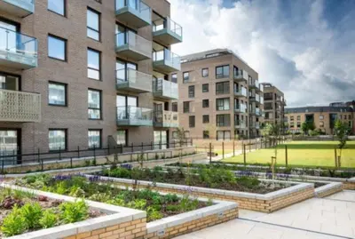 an apartment building with a garden in front of it at Citystay Living - Mill Park Apartments in Cambridge
