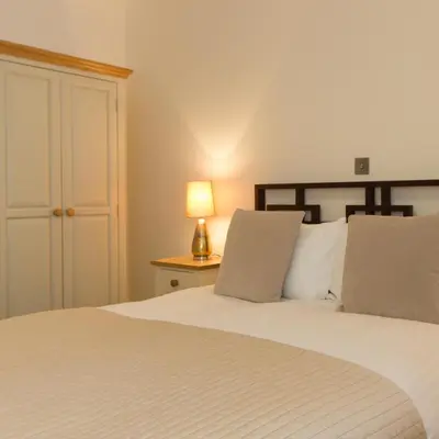 a bedroom with a white bed with a lamp on a table at Citystay Living - Mill Park Apartments in Cambridge