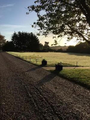 a field with a fence and a tree in the foreground at Sturmer Hall Hotel and Conference Centre in Haverhill