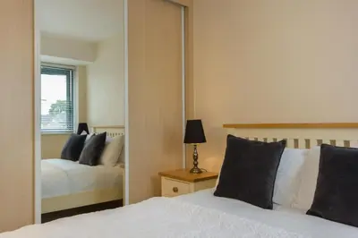 a bedroom with two beds and a mirror at Citystay Living - Dove House in Cambridge