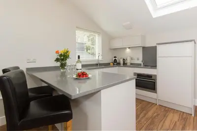 a kitchen with a table and a black chair at Citystay Living - The Dales in Cambridge