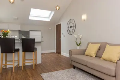 a living room with a couch and a kitchen at Citystay Living - The Dales in Cambridge