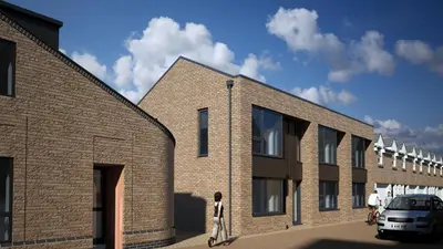 a person standing in front of a brick building at Citystay Living - The Dales in Cambridge