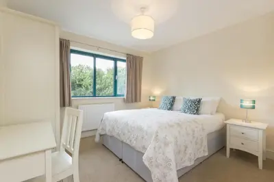 a white bedroom with a bed and a window at Citystay Living - Citygate in Cambridge