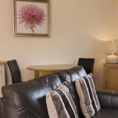 a living room with a leather couch and a table at Citystay Living - Citygate in Cambridge