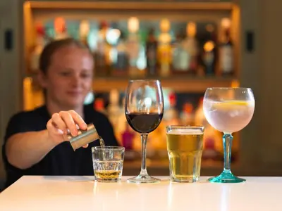 a woman sitting at a table with three glasses of wine at B&B HOTEL Ipswich in Ipswich