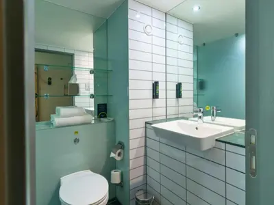 a bathroom with a sink and a toilet and a mirror at B&B HOTEL Ipswich in Ipswich