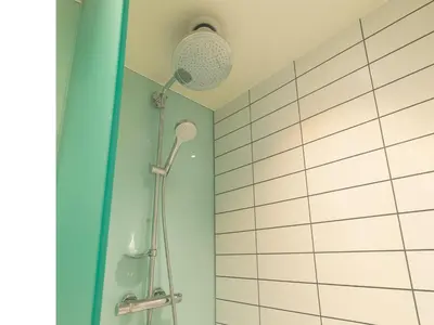 a shower in a bathroom with a blue wall at B&B HOTEL Ipswich in Ipswich