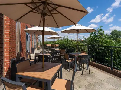 an outdoor patio with tables and chairs with umbrellas at B&B HOTEL Ipswich in Ipswich