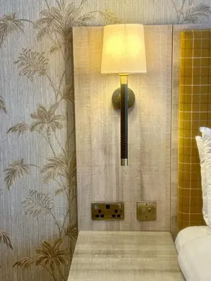 a lamp on a wall next to a bed at Hotel Coco in Felixstowe