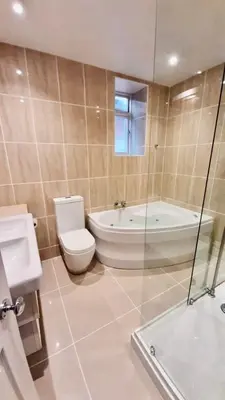a bathroom with a toilet and a tub and a sink at Hotel Coco in Felixstowe