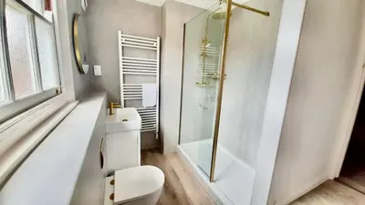 a bathroom with a toilet and a glass shower at Hotel Coco in Felixstowe