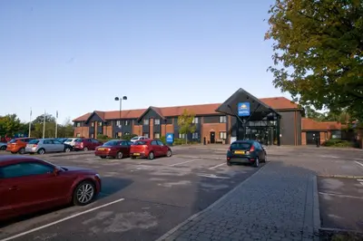 a parking lot with cars parked in front of a building at Days Inn Stevenage North in Baldock