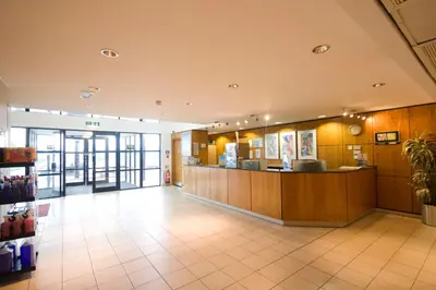 a large lobby with a counter in a building at Days Inn Stevenage North in Baldock