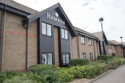 a building with a sign on the front of it at Ramada Cambridge in Cambridge