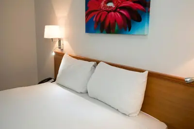 a bedroom with a bed with two white pillows at Ramada Cambridge in Cambridge