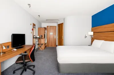 a room with a bed and a desk with a computer at Holiday Inn Express Braintree by IHG in Braintree