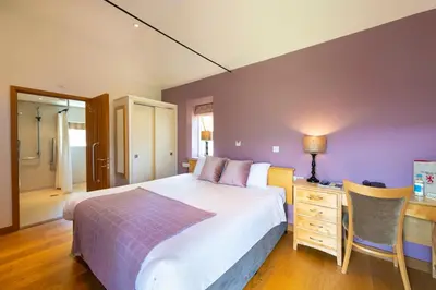 a bedroom with a large bed and a desk with a night stand at The Red Lion Hinxton in Hinxton
