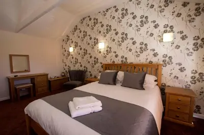 a bedroom with a bed with two towels on it at The Crown Inn Hotel in Long Melford