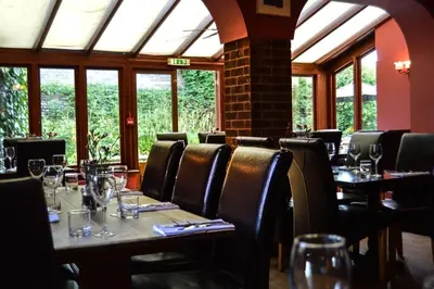 a dining room with tables and chairs and windows at The Crown Inn Hotel in Long Melford