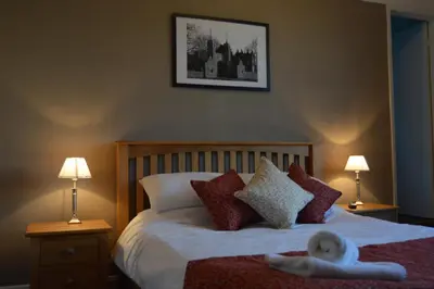 a bedroom with a bed with a doll on it at The Crown Inn Hotel in Long Melford