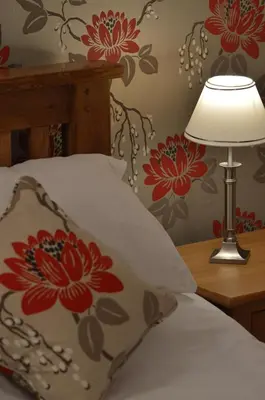 a bed with a pillow and a lamp on a table at The Crown Inn Hotel in Long Melford