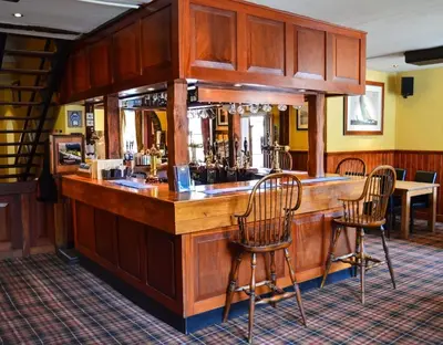 a bar in a pub with two chairs in a room at The Crown Inn Hotel in Long Melford