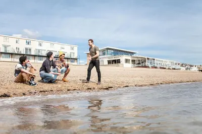 a group of people sitting on the beach at University of Essex - Southend Campus in Southend-on-Sea