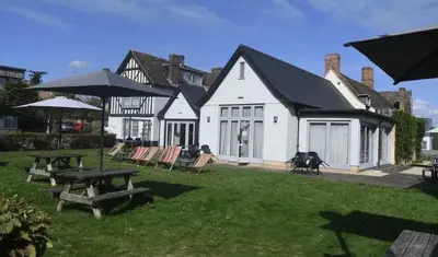 a house with a picnic table and chairs in the yard at The Red Lion Hotel in Cambridge