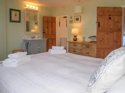 a bedroom with a large bed with towels on it at Ivy Cottage in Aldeburgh