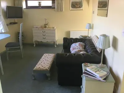 a living room with a couch and a table at Pheasant Suites in Colchester